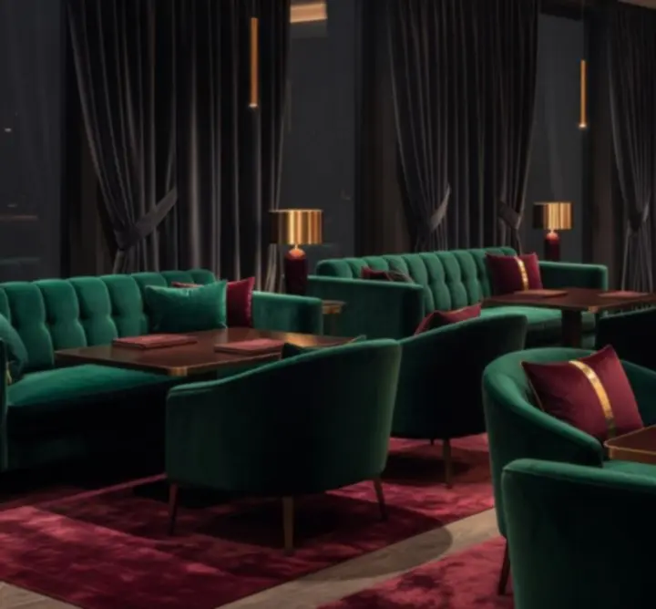 Chic emerald and black lounge interior at Aus Nights with plush seating and warm lighting